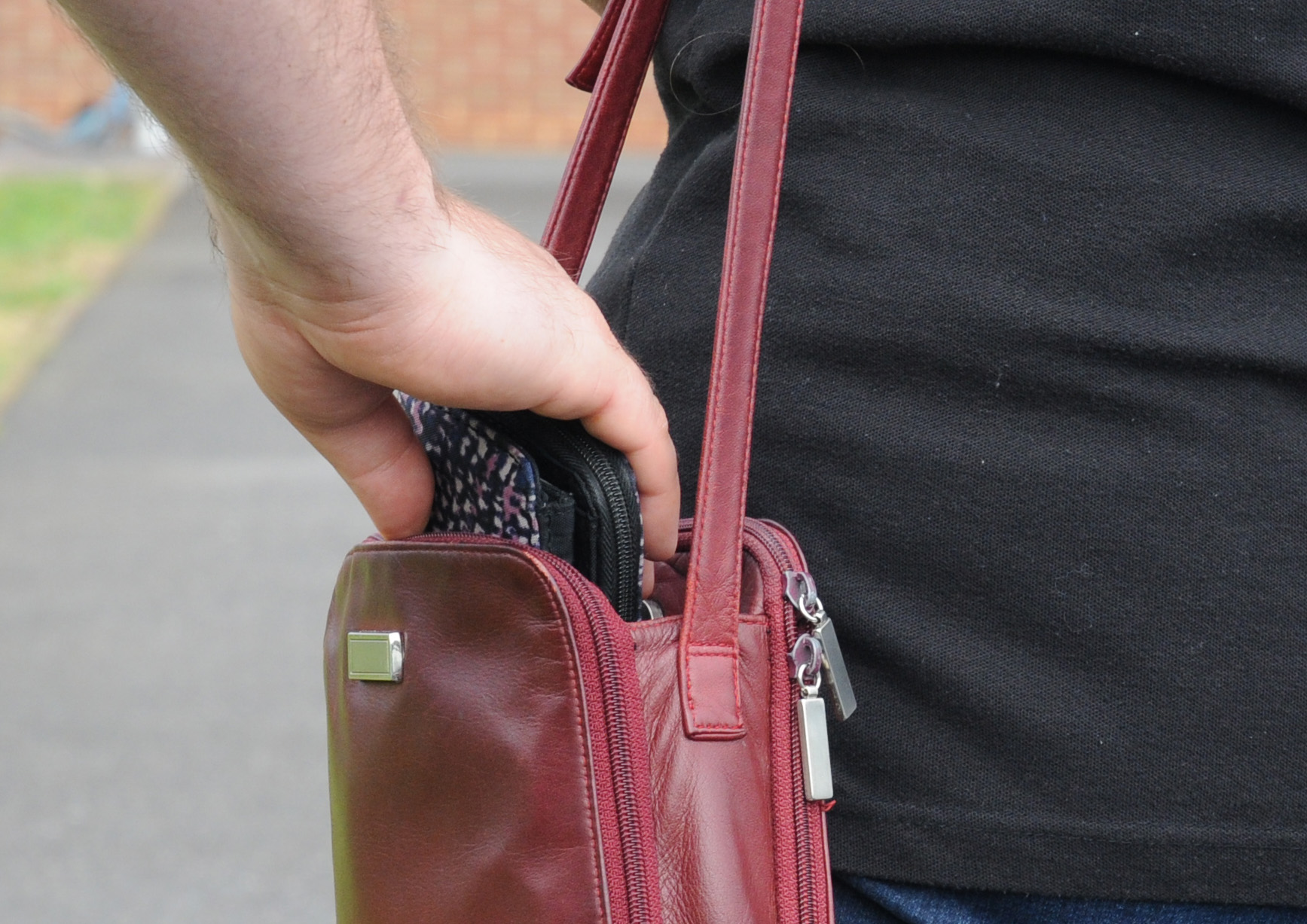 Image of a purse being stolen from a bag