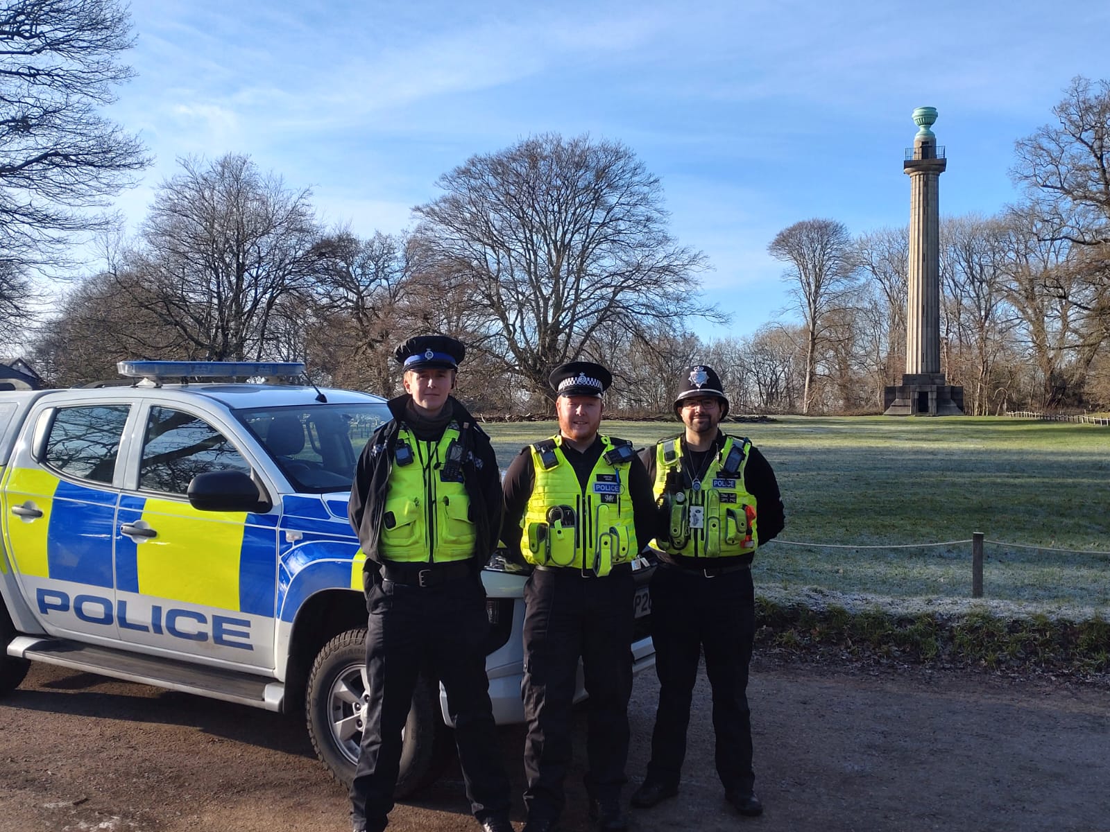 Joey, Ian and Phil standing in front of a police car 
