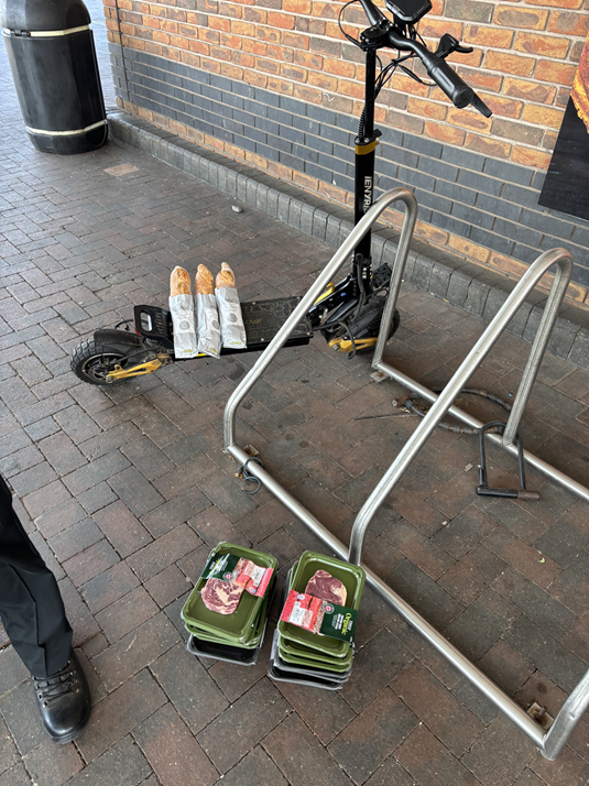 e scooter with baguettes on, steak is also pictured